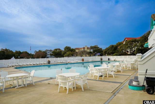 community pool with fence and a patio area