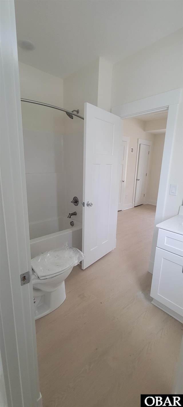 bathroom featuring toilet,  shower combination, and vanity