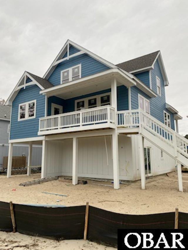 back of property featuring a balcony and stairs