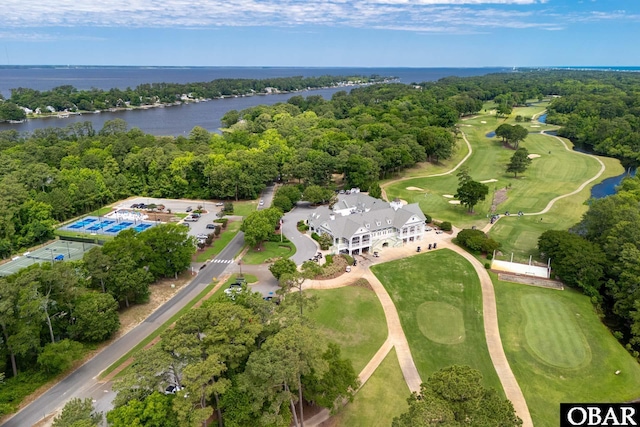 aerial view featuring view of golf course, a water view, and a view of trees