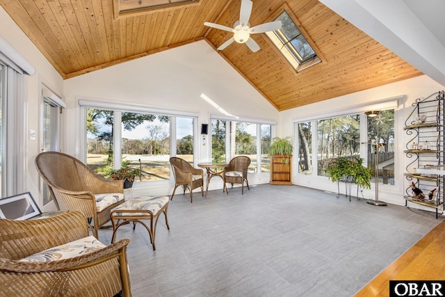 sunroom with vaulted ceiling with skylight, wood ceiling, and ceiling fan