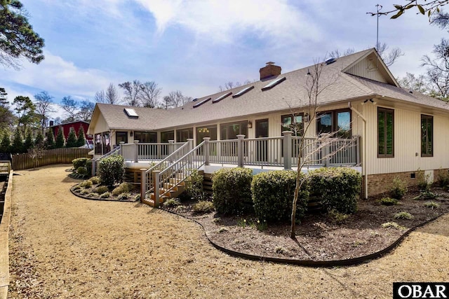 back of property with roof with shingles, a chimney, stairway, crawl space, and fence