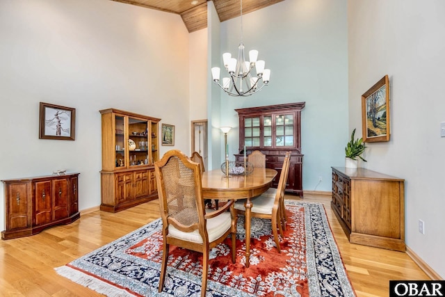 dining area with baseboards, wooden ceiling, light wood-style flooring, high vaulted ceiling, and a chandelier