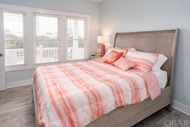 bedroom with light wood-type flooring and baseboards