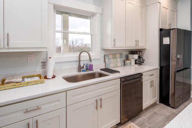 kitchen featuring black dishwasher, white cabinetry, a sink, light stone countertops, and stainless steel fridge with ice dispenser