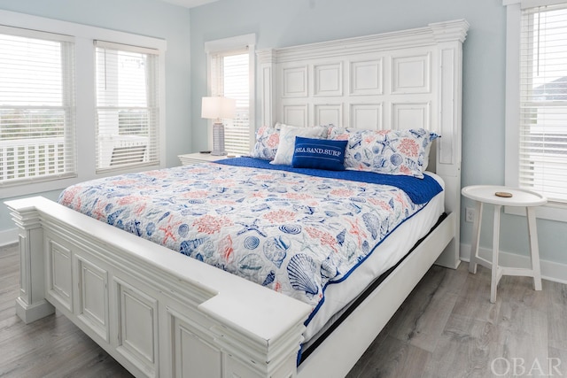 bedroom featuring light wood-type flooring, baseboards, and a closet