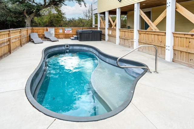 view of swimming pool with a patio, a fenced backyard, and a hot tub