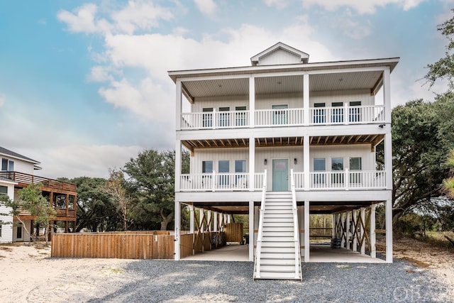 coastal home featuring a carport, board and batten siding, and gravel driveway