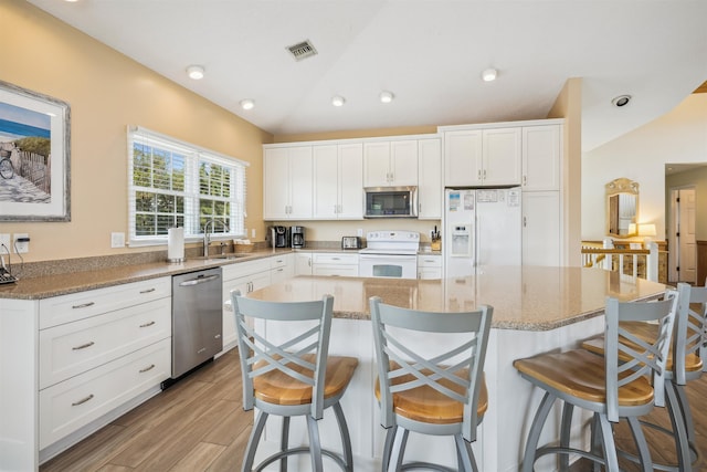 125 Foresail Ct Lot 37, Duck, NC 27949 - kitchen featuring appliances with stainless steel finishes, vaulted ceiling, light wood-type flooring, white cabinets, and a sink