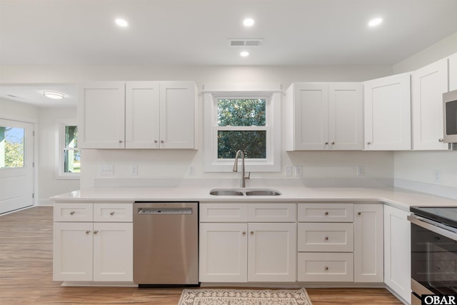 kitchen with visible vents, a sink, light countertops, appliances with stainless steel finishes, and white cabinetry