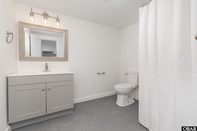 bathroom featuring vanity, toilet, baseboards, and concrete flooring