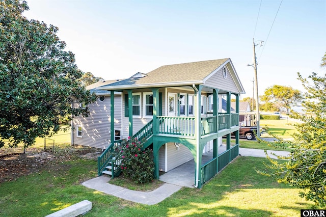 view of front of home with a porch, a shingled roof, stairs, and a front yard