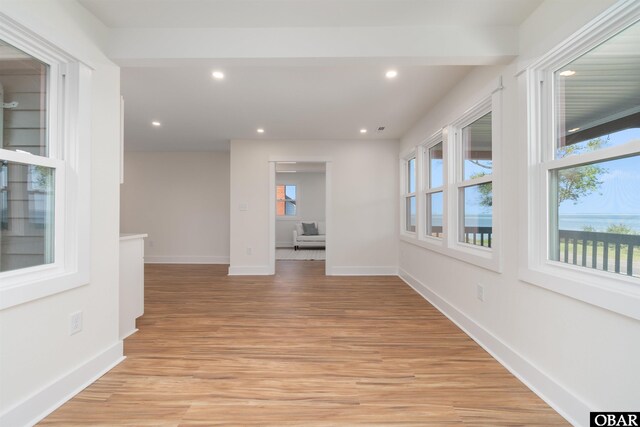 unfurnished room featuring light wood finished floors, recessed lighting, and baseboards