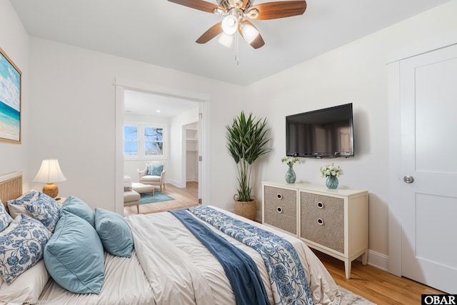 bedroom with a ceiling fan, light wood-style floors, and baseboards