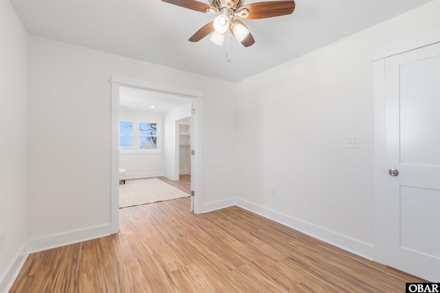 unfurnished room featuring light wood-style floors, baseboards, and ceiling fan