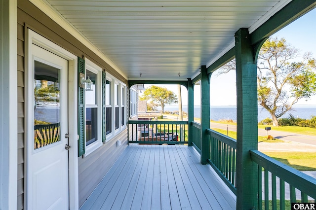 deck with a water view and covered porch