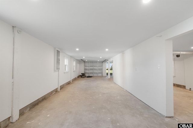 basement featuring electric panel, recessed lighting, and a healthy amount of sunlight