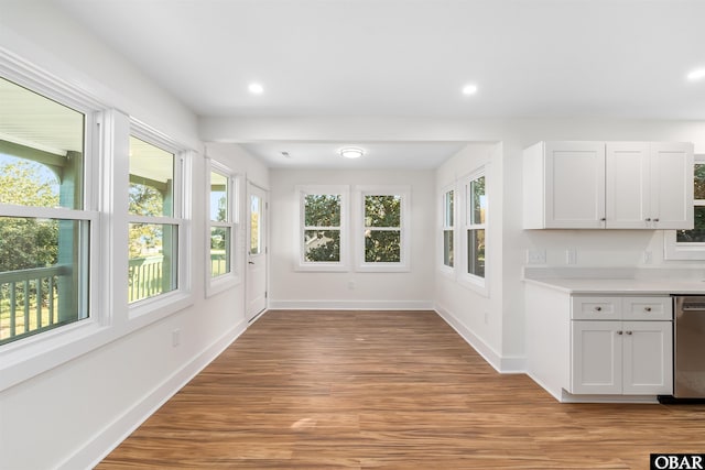 unfurnished dining area featuring light wood-style flooring, recessed lighting, and baseboards