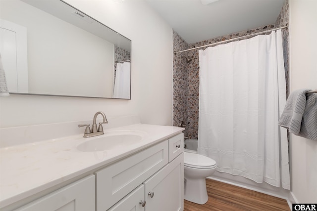 bathroom featuring vanity, toilet, shower / tub combo, and wood finished floors