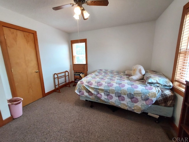 carpeted bedroom with baseboards and a ceiling fan