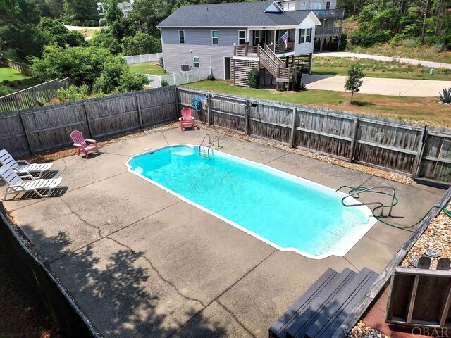 view of pool featuring a fenced in pool, a patio area, a fenced backyard, and stairway