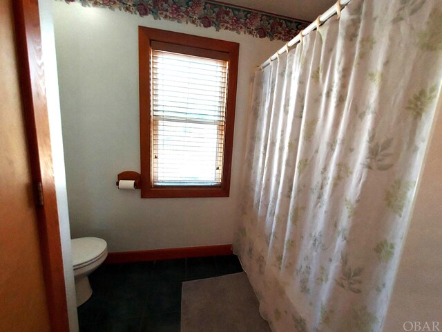 full bathroom featuring baseboards, toilet, and tile patterned floors