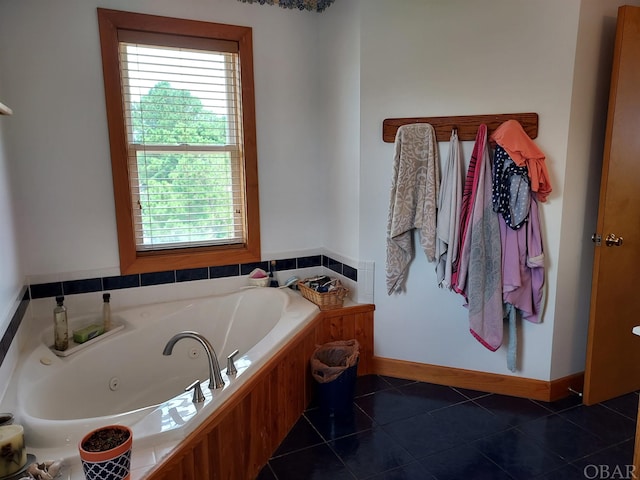 bathroom featuring a whirlpool tub, baseboards, and tile patterned floors