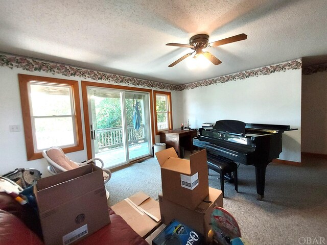 sitting room with a textured ceiling, carpet floors, and a ceiling fan