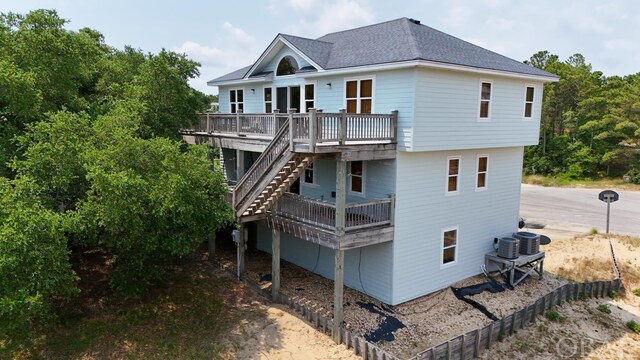 rear view of property featuring a shingled roof, stairway, a wooden deck, and central air condition unit