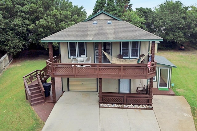 view of front of property featuring an attached garage, a deck, a front lawn, and concrete driveway