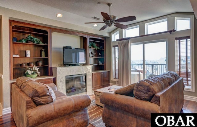 living room with a fireplace, visible vents, baseboards, built in features, and dark wood-style floors