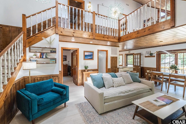 living room with visible vents, wainscoting, a high ceiling, stairs, and a chandelier