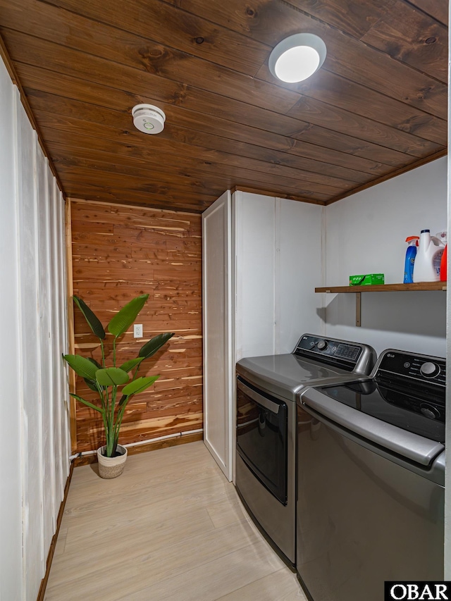 washroom with laundry area, light wood-type flooring, wood ceiling, and washer and dryer