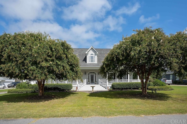 view of front of property featuring roof with shingles and a front yard