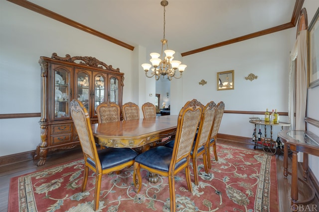 dining space featuring ornamental molding, wood finished floors, and baseboards