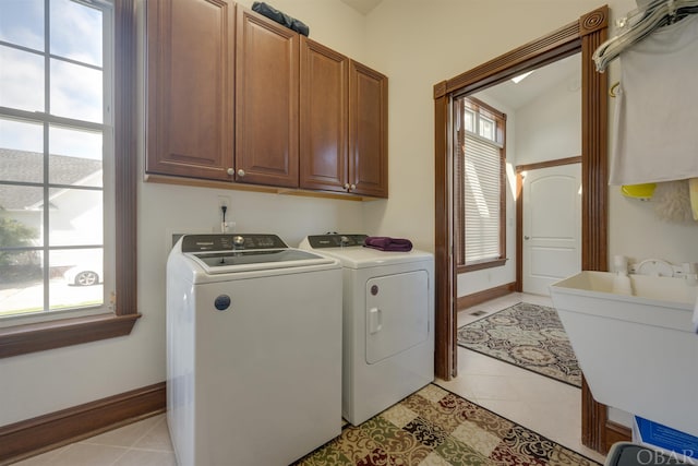 laundry area featuring cabinet space, baseboards, a sink, and washing machine and clothes dryer