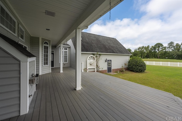 deck featuring a water view, fence, and a lawn