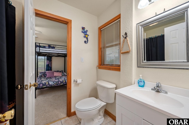 bathroom featuring ensuite bathroom, tile patterned flooring, toilet, vanity, and baseboards