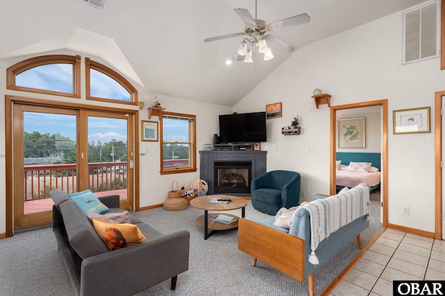 living room featuring visible vents, vaulted ceiling, a fireplace, and light tile patterned floors