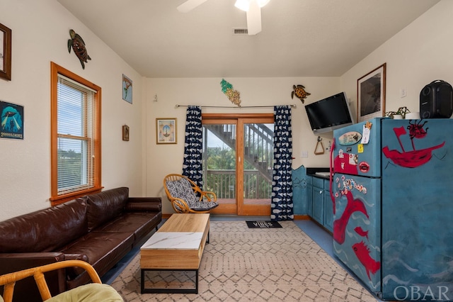 living area featuring a ceiling fan and visible vents