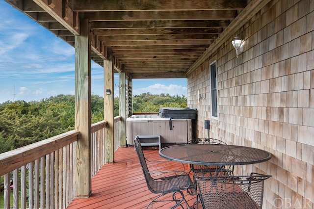 wooden terrace with a hot tub and outdoor dining area