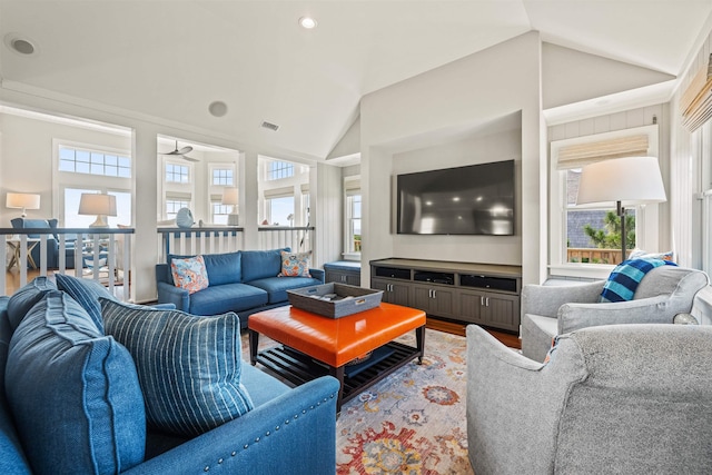 living area featuring vaulted ceiling, wood finished floors, and visible vents