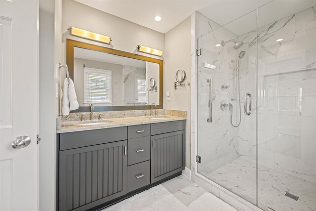 bathroom with marble finish floor, double vanity, a sink, and a marble finish shower