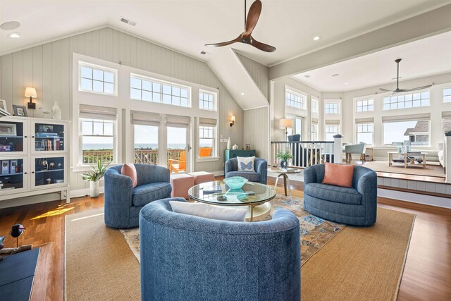 living area with ceiling fan, high vaulted ceiling, light wood-type flooring, and visible vents