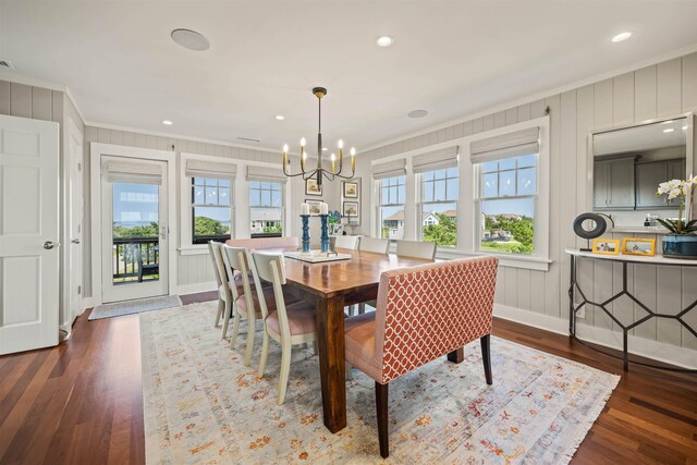 dining room with a notable chandelier, dark wood-type flooring, crown molding, and recessed lighting