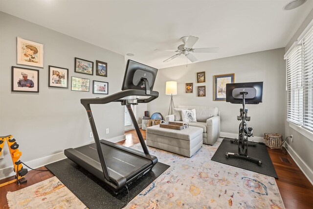 workout room with visible vents, ceiling fan, baseboards, and wood finished floors