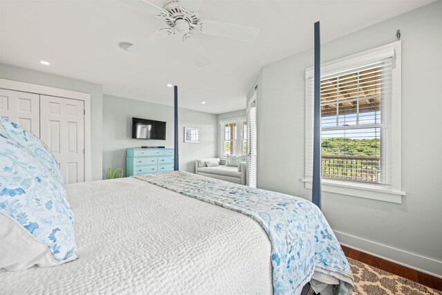 bedroom with ceiling fan, multiple windows, wood finished floors, and baseboards