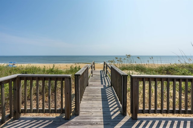 view of property's community with a water view and a view of the beach