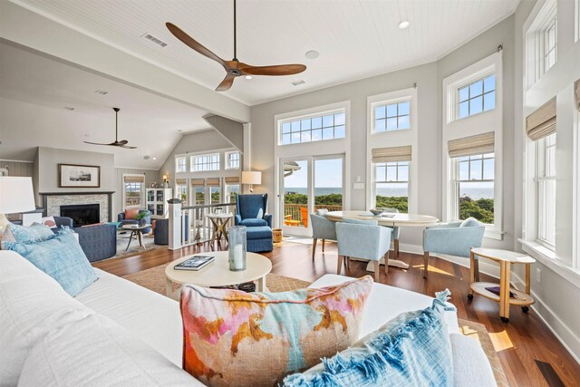 living room with visible vents, a fireplace, baseboards, and wood finished floors