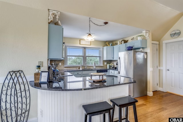 756 Lakeview Ct Lot 47, Corolla, NC 27927 - kitchen featuring stainless steel appliances, a peninsula, light wood-style flooring, a sink, and dark stone countertops